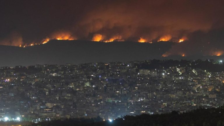 Η άποψη περιοχής της Αθήνας με φόντο τη φωτιά.